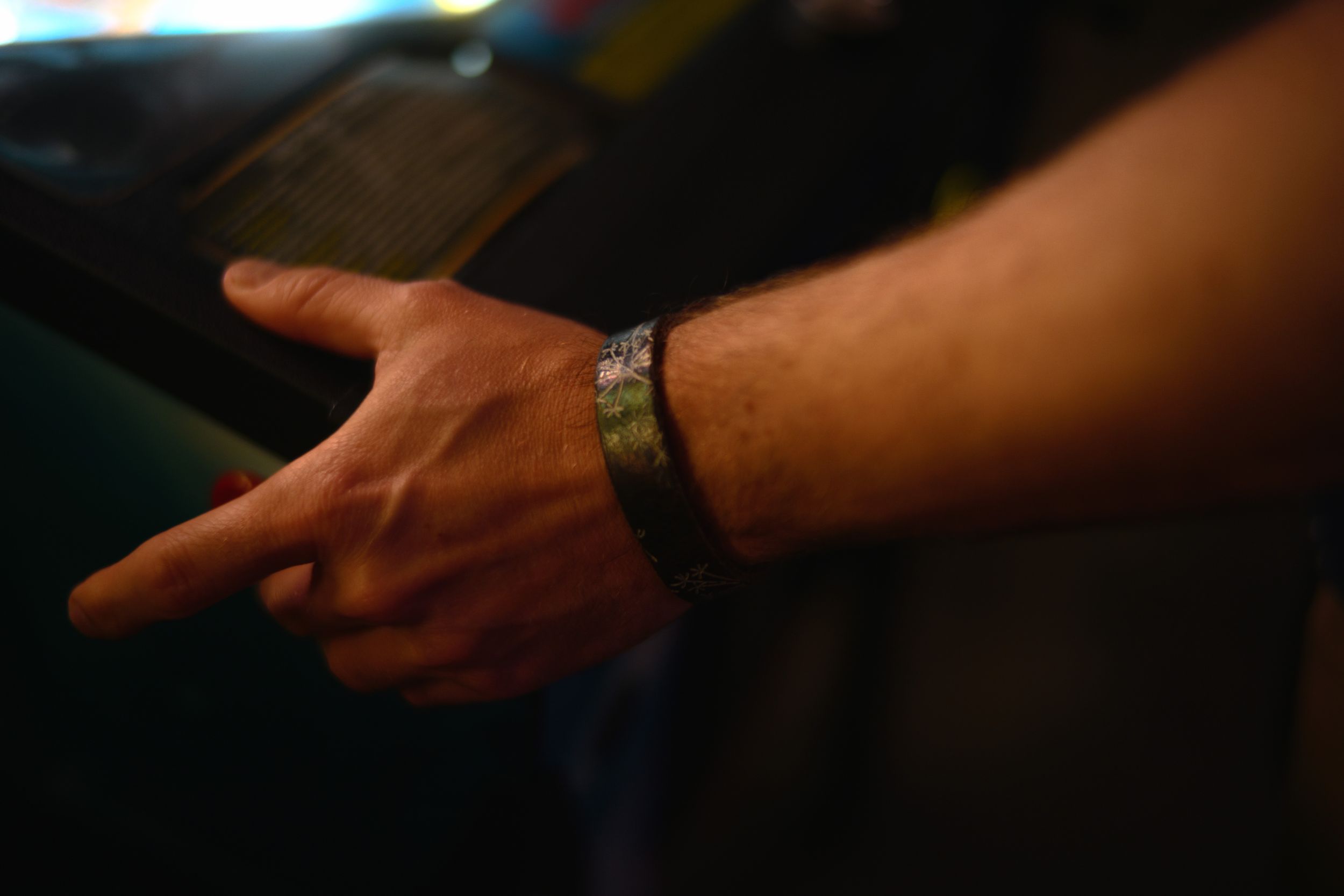 Close-up shot of a hand wearing a watch against a dark background.