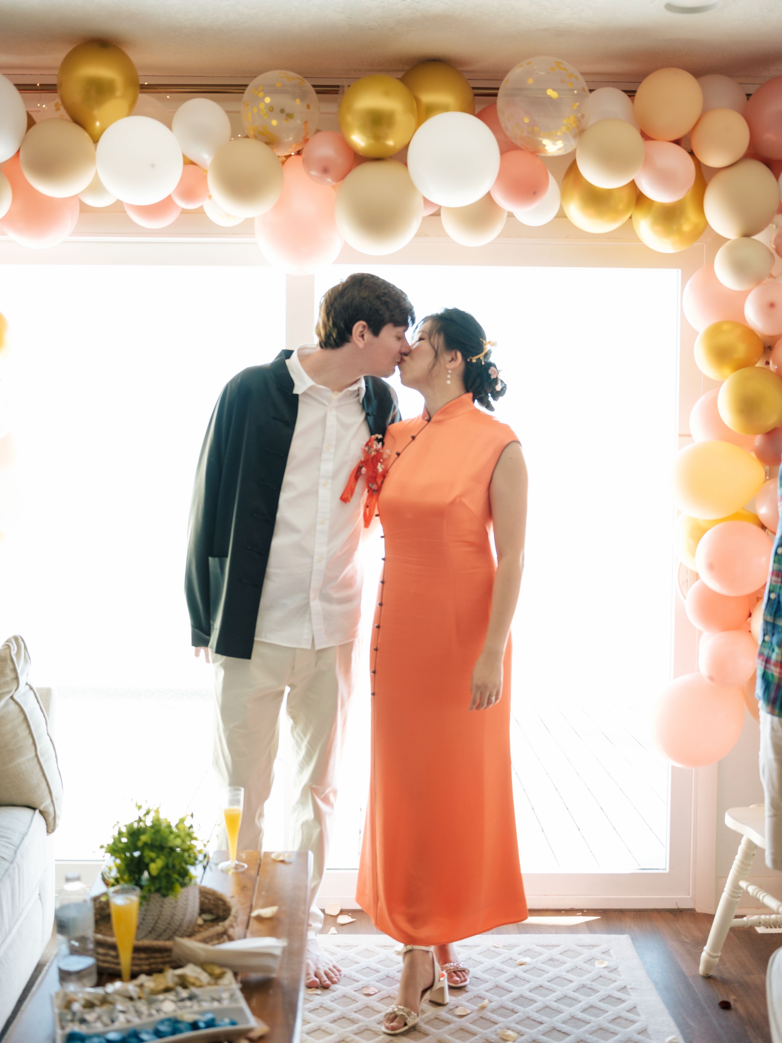 Pastel and gold balloon arch decorates an elegant indoor event space.