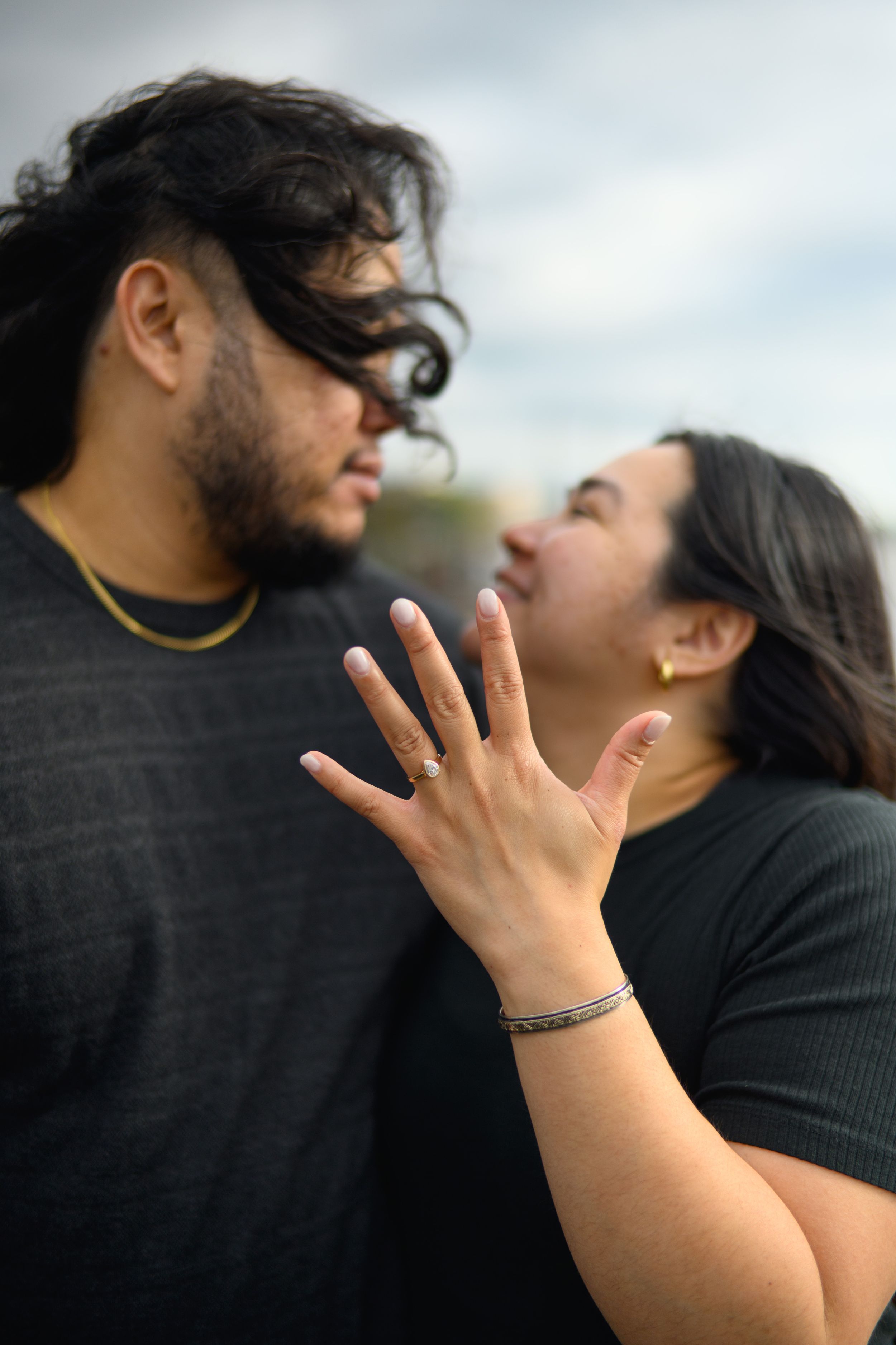 A close-up photo series showing a person's hand displaying an engagement ring against a blurred outdoor background.