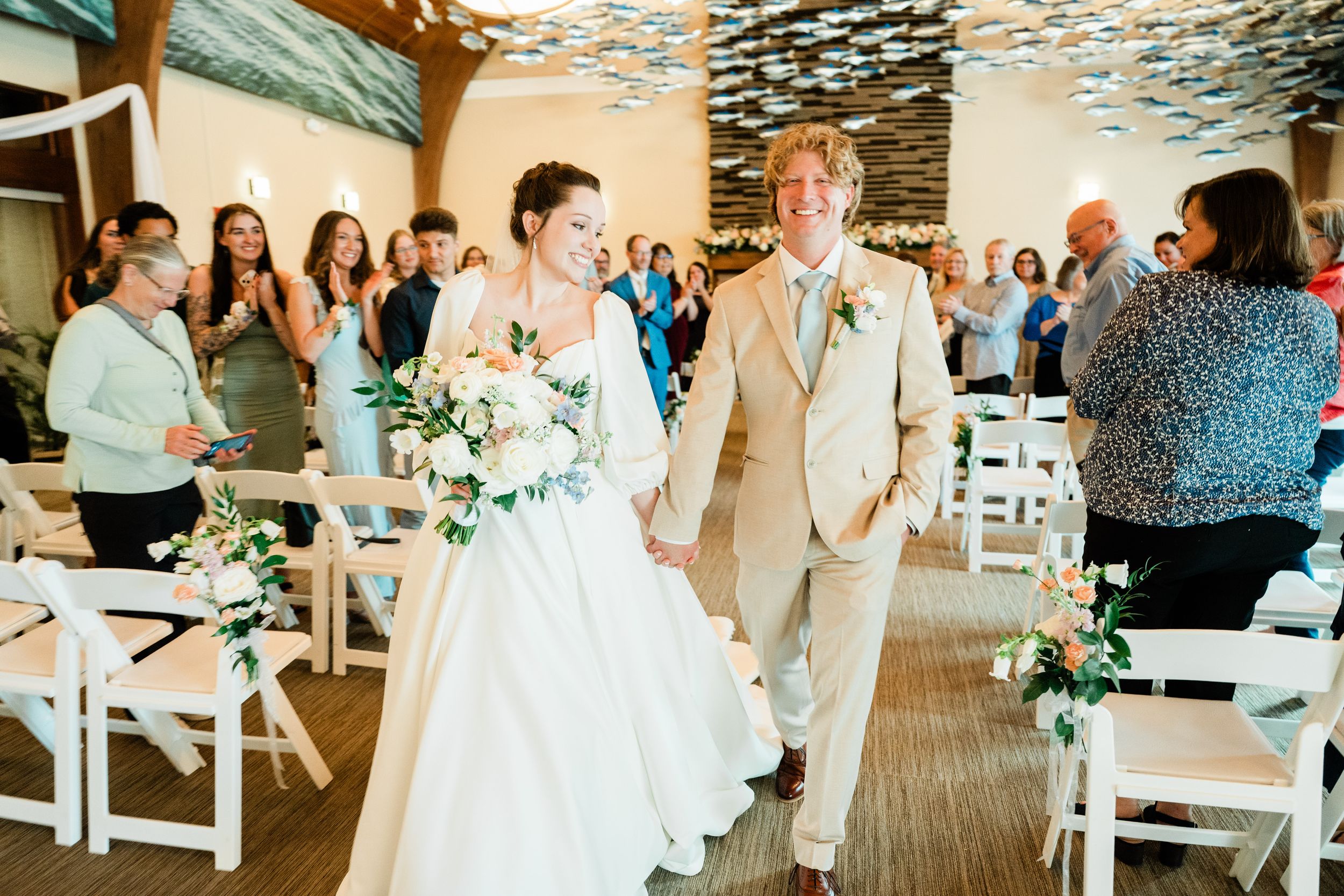 Reception venue decorated with string lights and white chairs for a wedding celebration.
