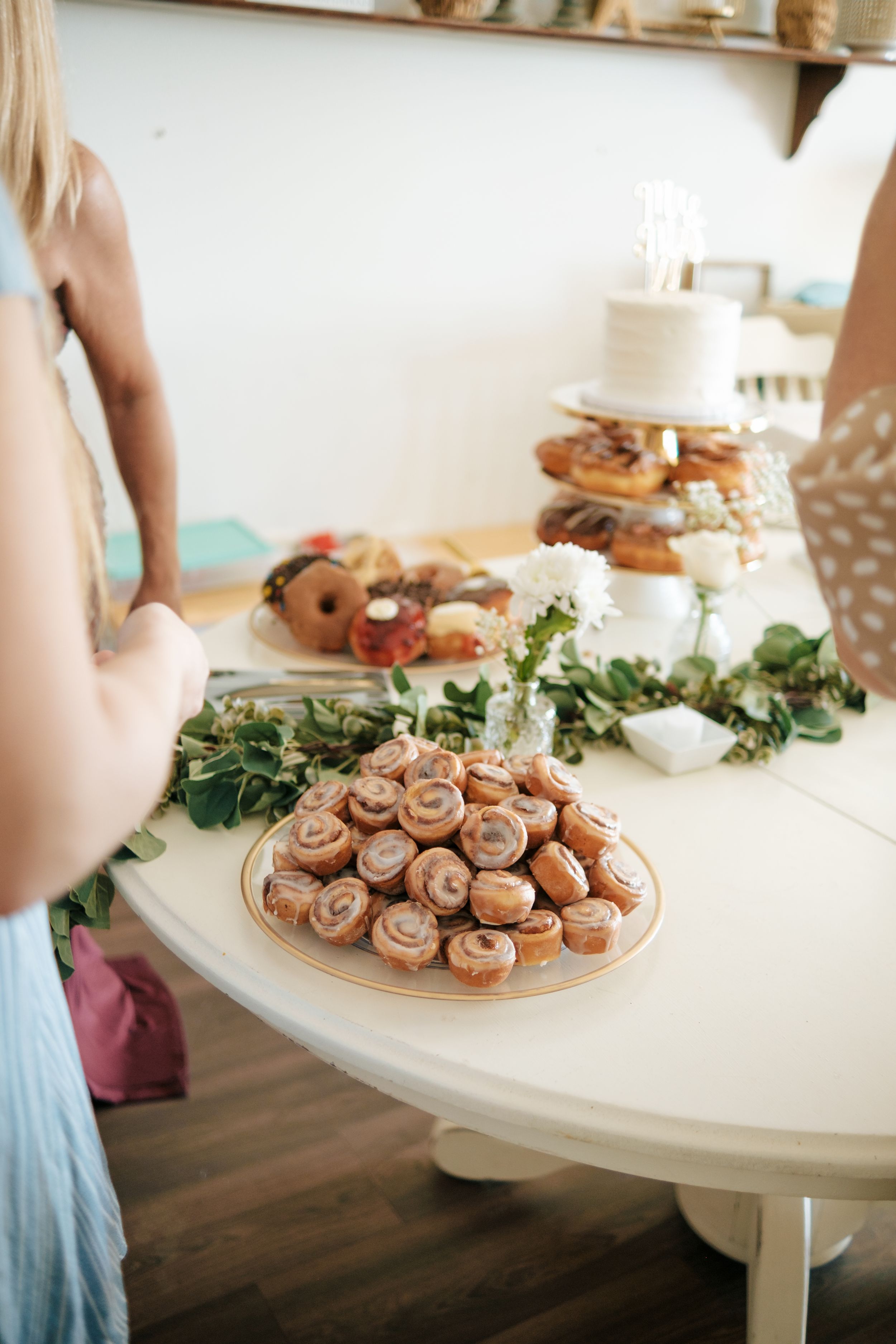 Dessert table displaying platters of small pastries and treats at a special event.