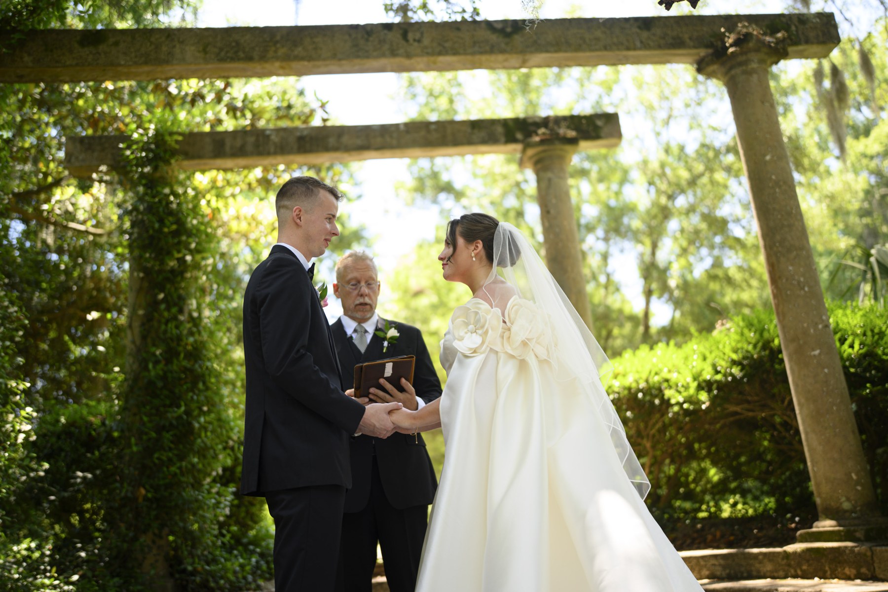 Lizzy and her partner holding hands during their garden wedding ceremony