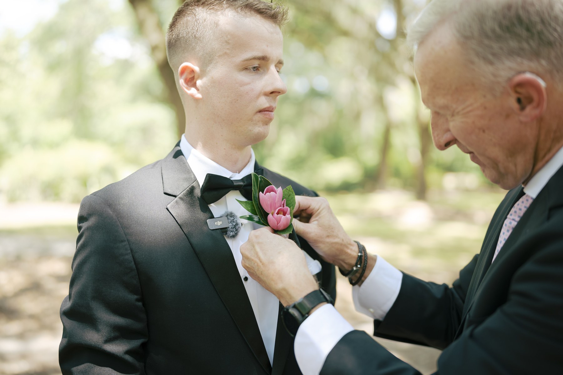 The groom having his bow tie adjusted before the ceremony