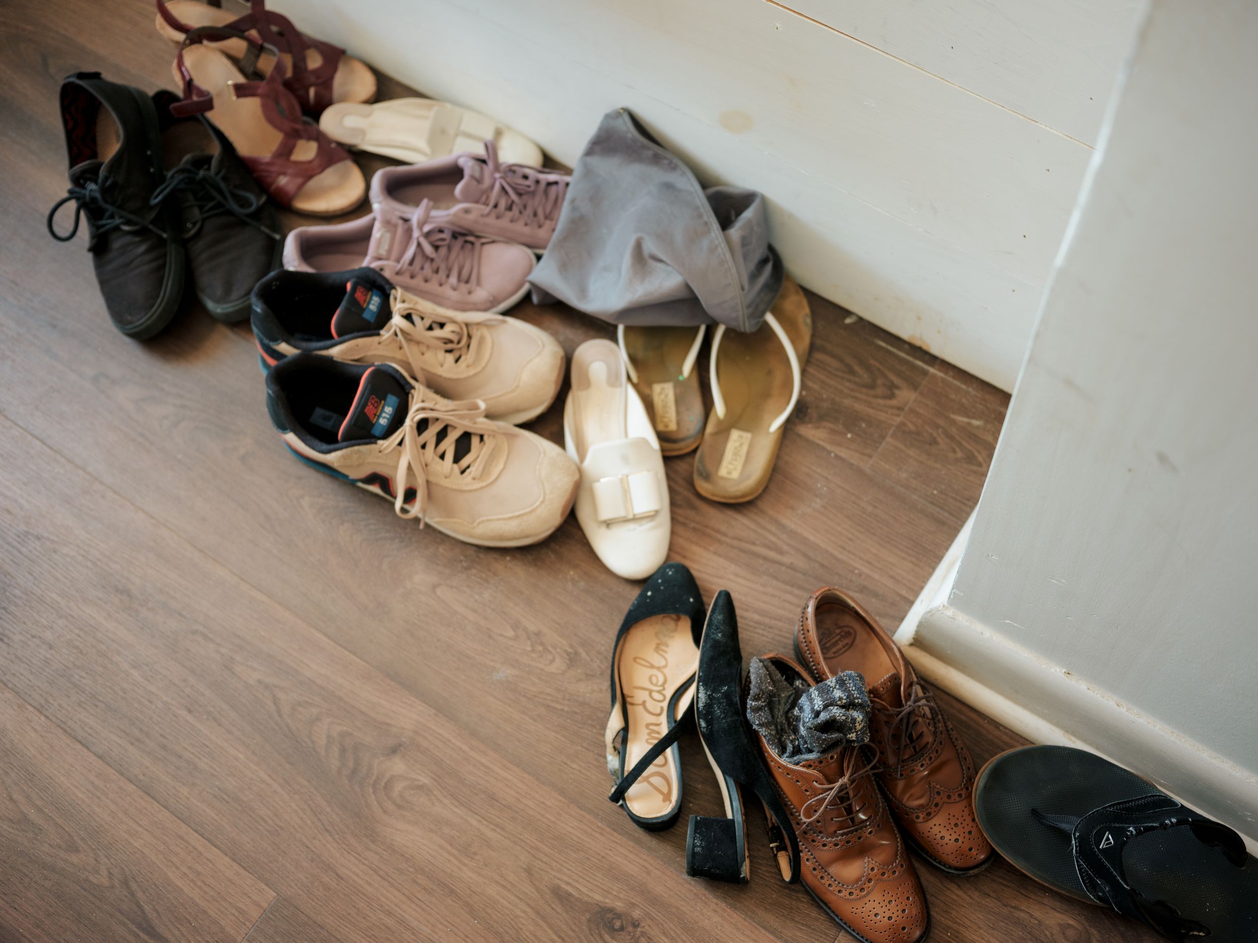 Collection of wedding shoes including heels and flats displayed on wooden flooring.