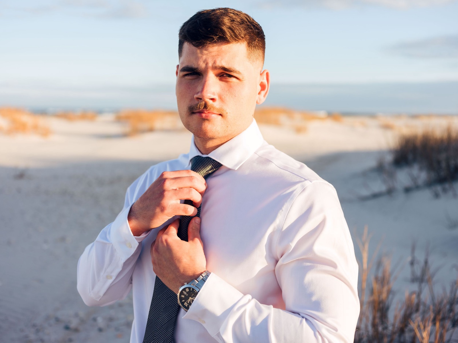 groom getting ready on the beach