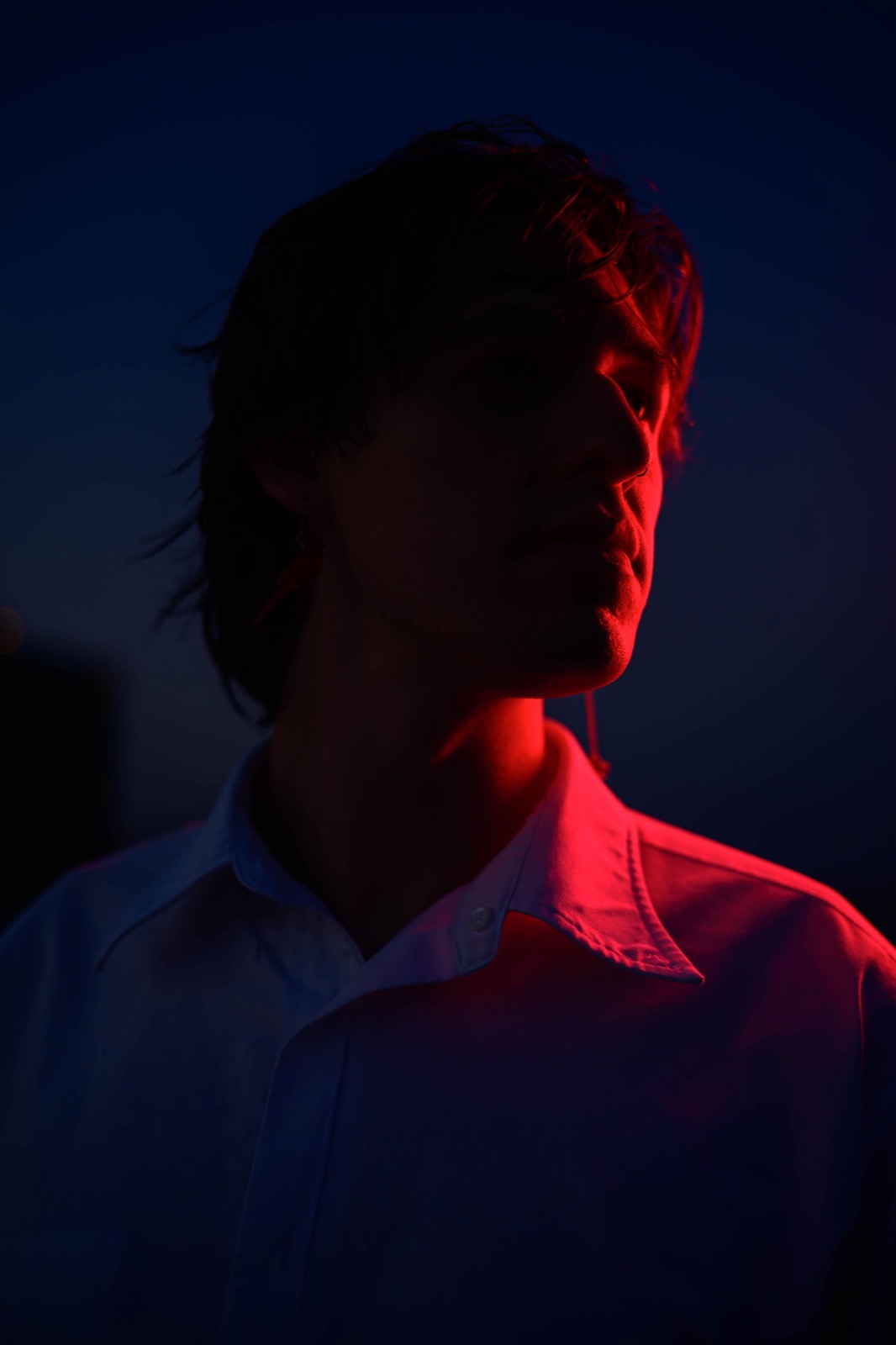 Dramatic red lighting creates a silhouette against a dark blue twilight sky.