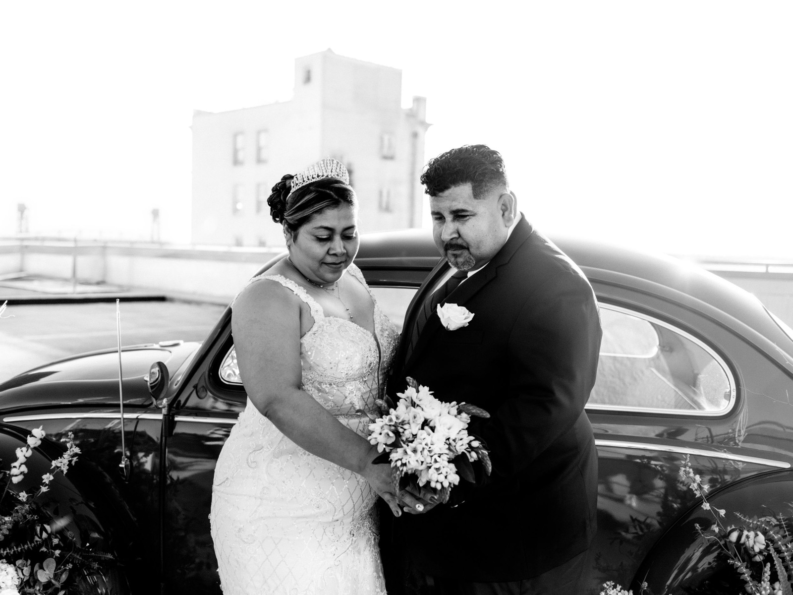 Classic black and white wedding portrait by vintage car.