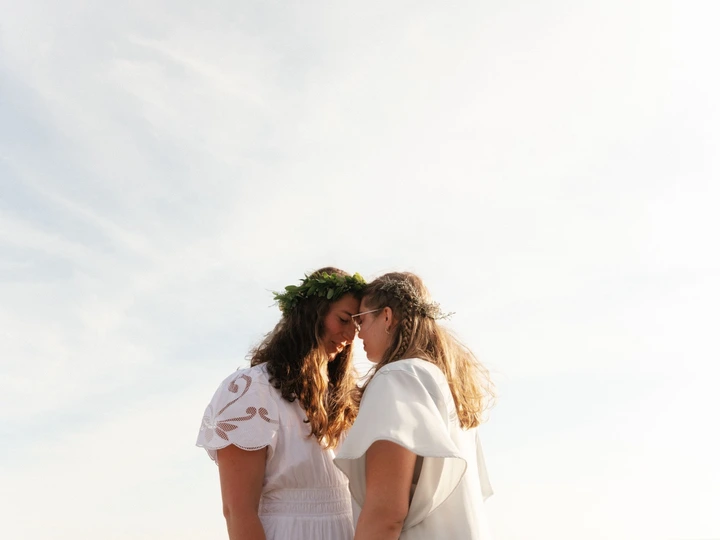 Couple leaning together beneath an open sky
